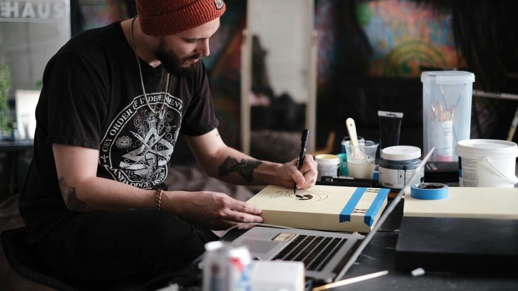 a person with a red hat writing on a laptop