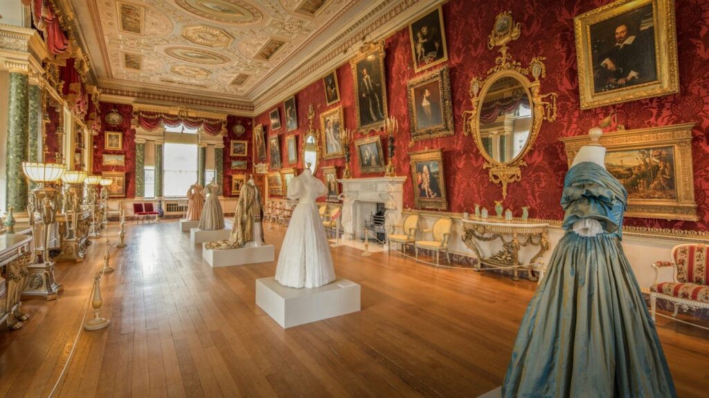 Elegant ballroom with historical dresses on display