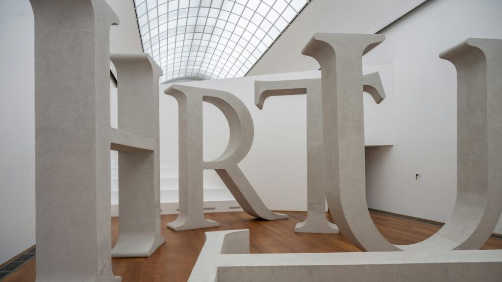 Large white letters displayed as art in a modern gallery