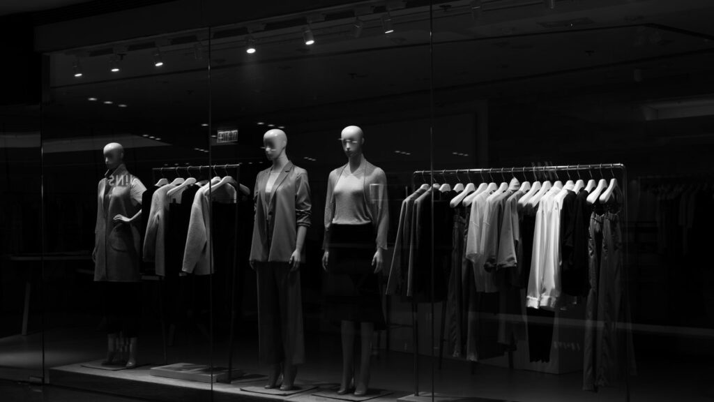 Mannequins display clothing in a dimly lit store